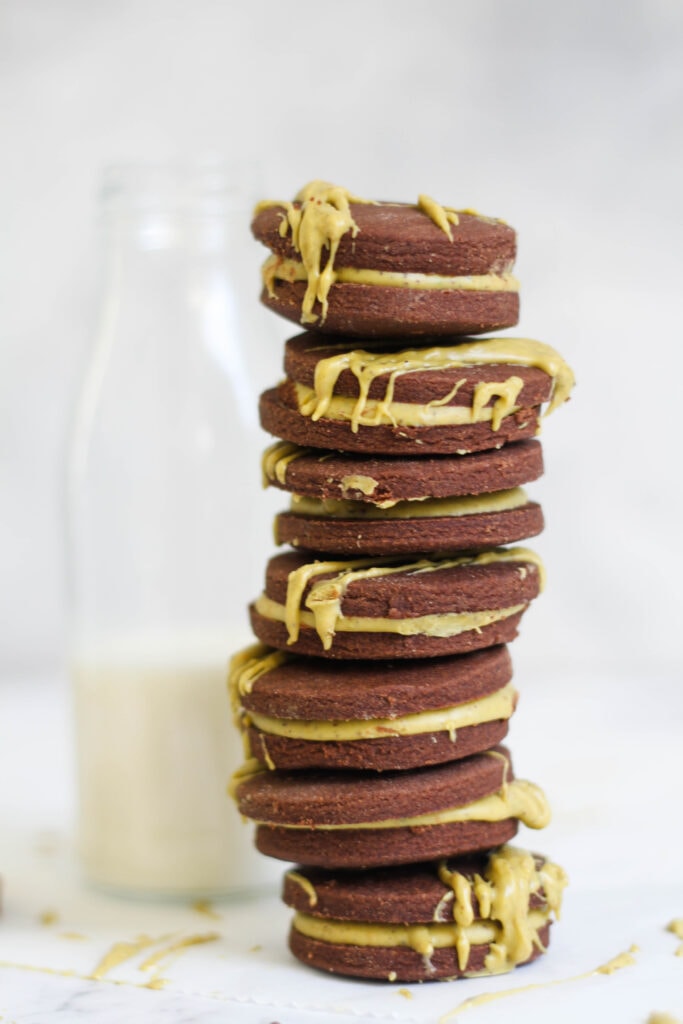 Chocolate pistachio cookies stack against a bottle of milk