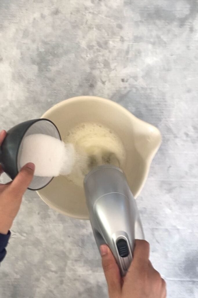 Pouring sugar into egg whites