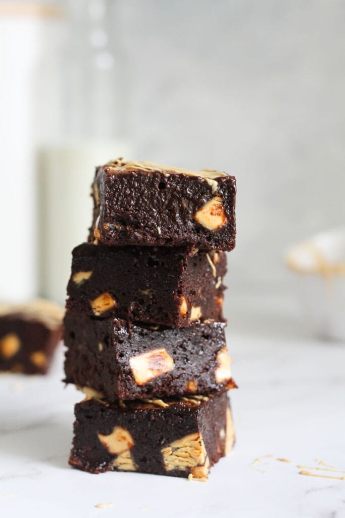 4 squares of caramilk brownies stacked on top of each other.