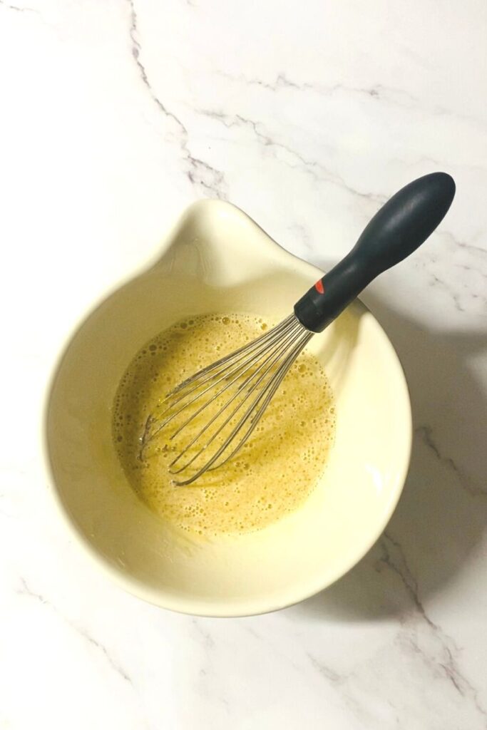 Wet ingredients in bowl with whisk