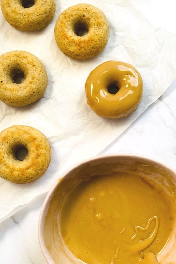 dipping donuts into coffee glaze