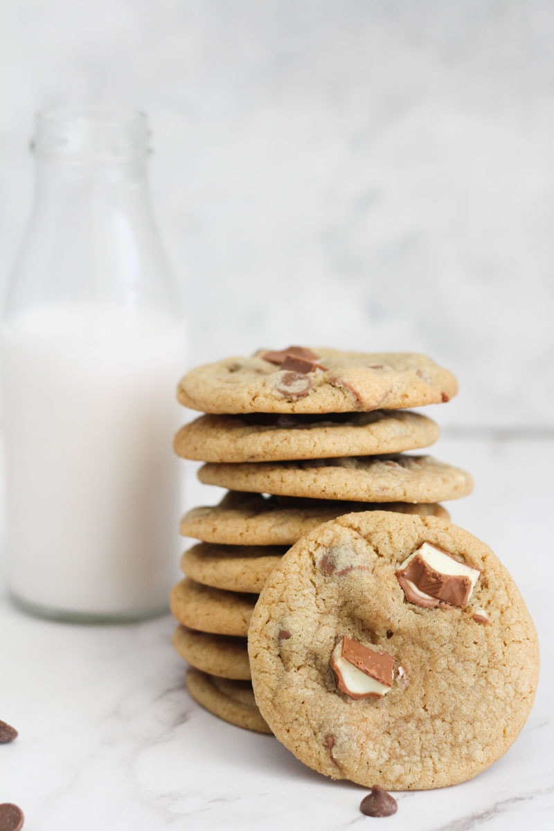 cookies stacked with one facing the camera and a jar of milk