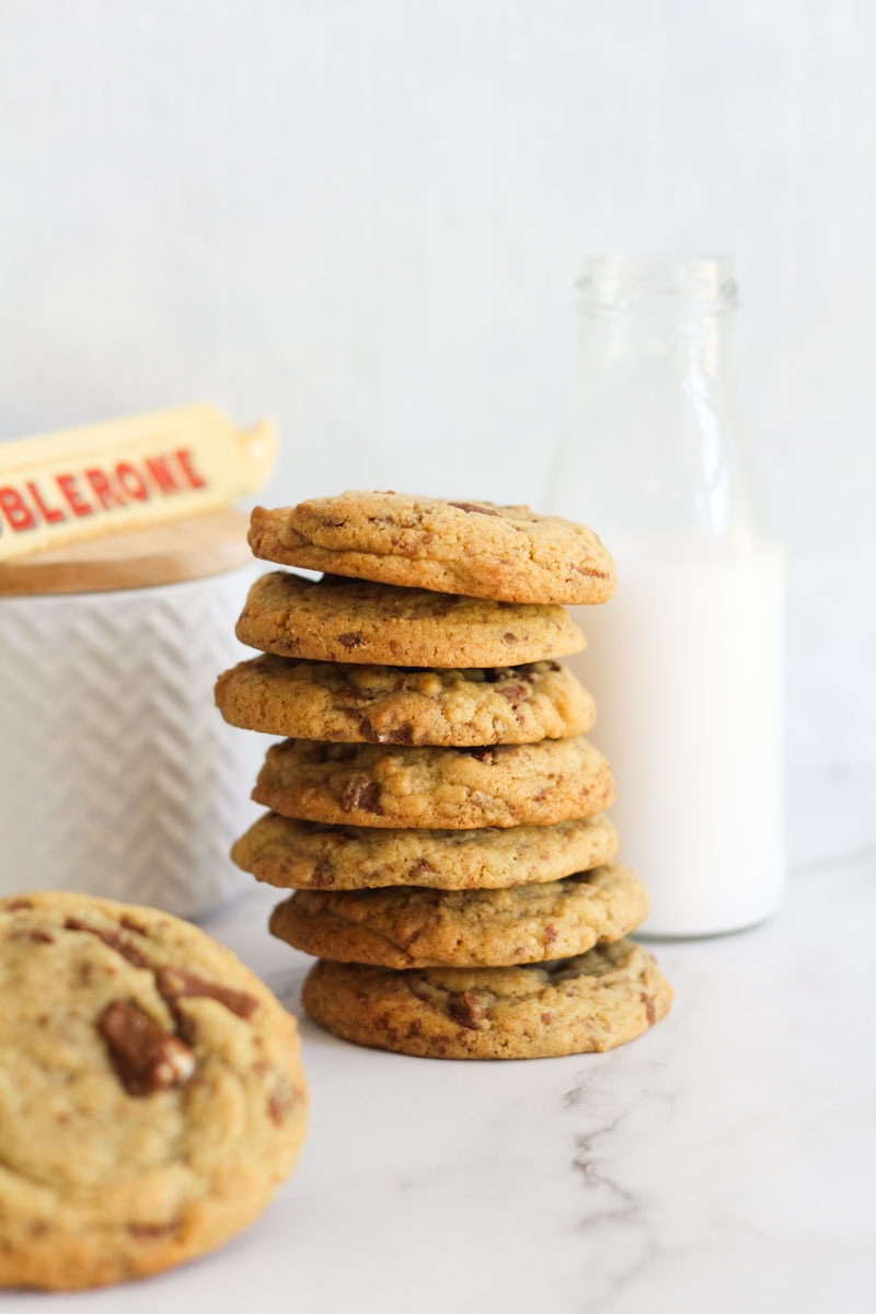 Cookies stacked against a milk jug.