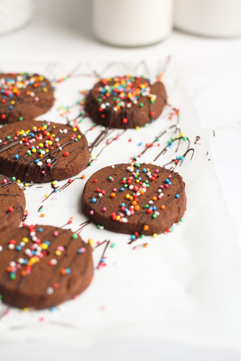 slice and bake Chocolate shortbread cookies that are chocolate drizzled with sprinkles.