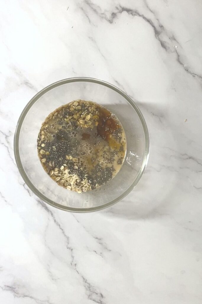 Oats, chia seeds, sugar in a bowl with wet ingredients.