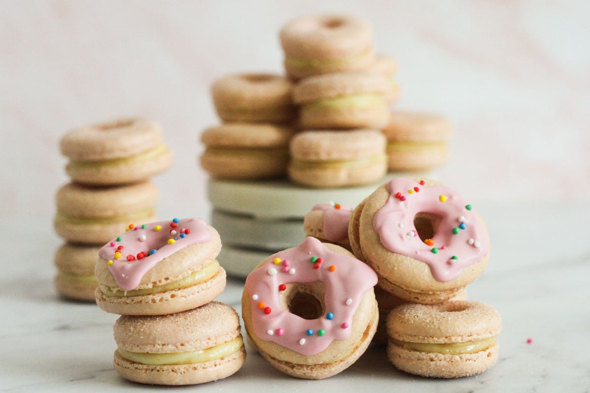 Cinnamon sugar and glazed donut macarons stacked together.