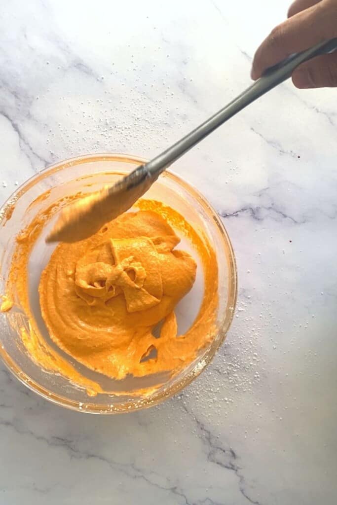 Pumpkin spice macaron batter mixed in bowl.