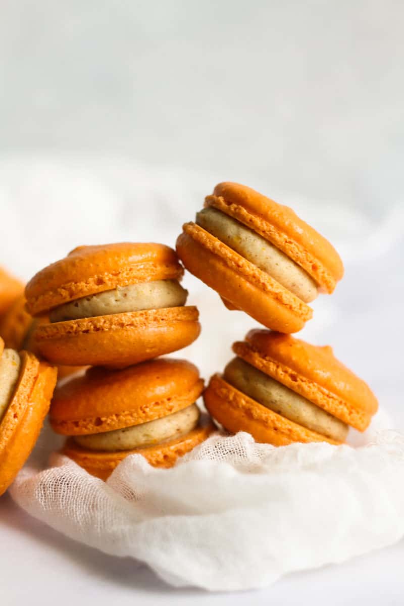 Pumpkin spice macarons stacked on each other.