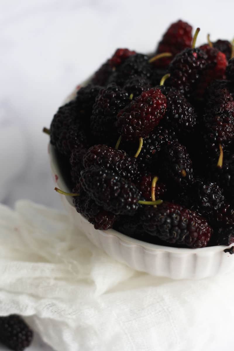 Fresh mulberries stacked in a bowl.