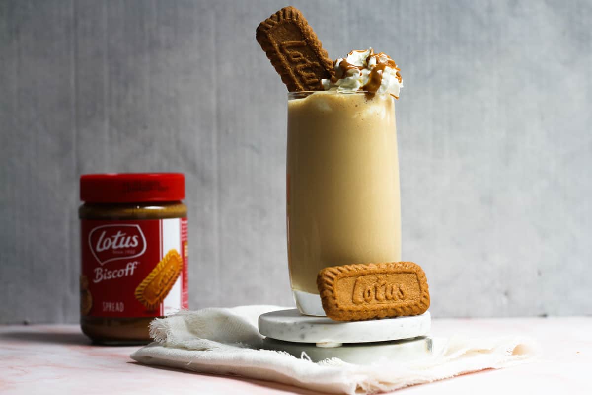 Biscoff milkshake with jar of biscoff in the background.