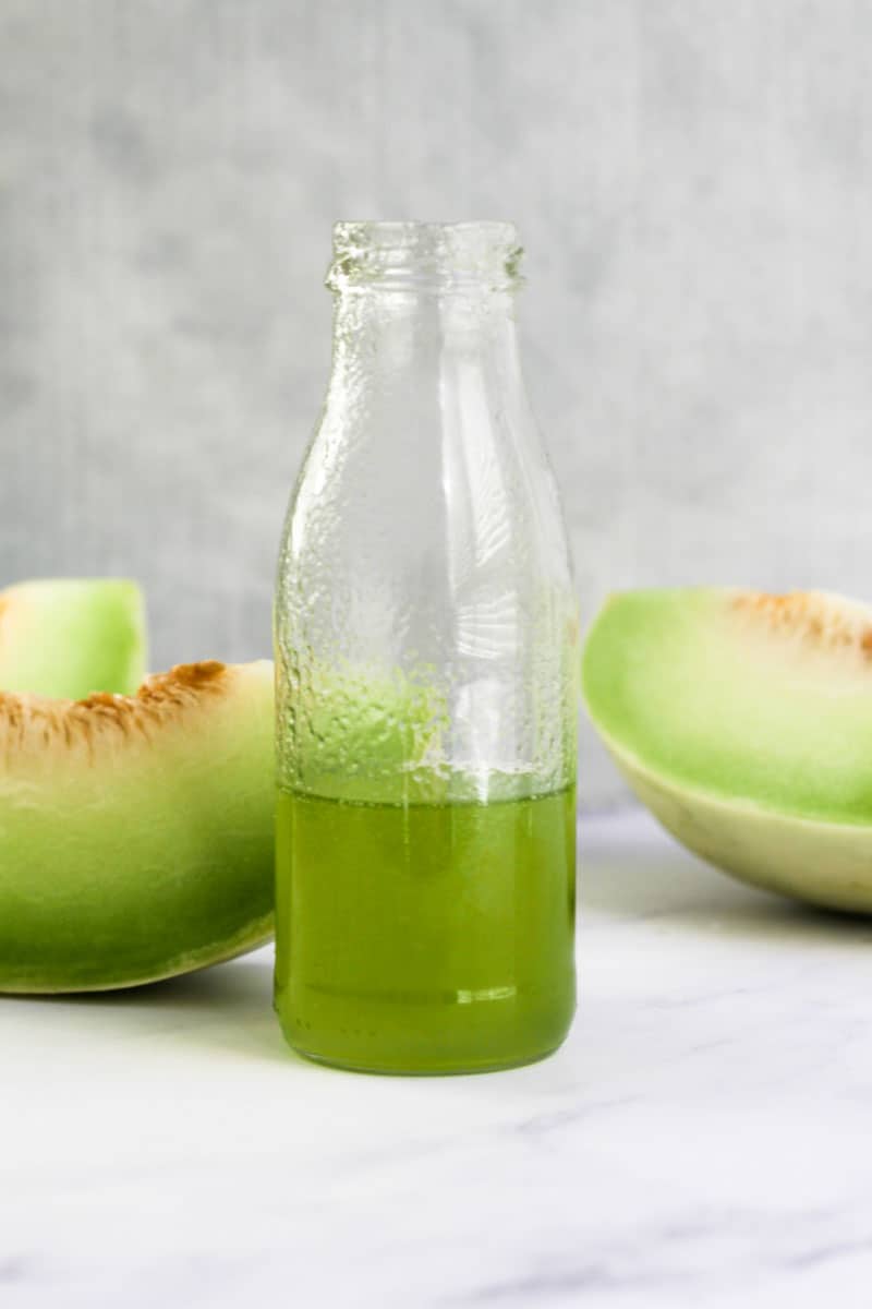 Honeydew syrup in small glass jug.