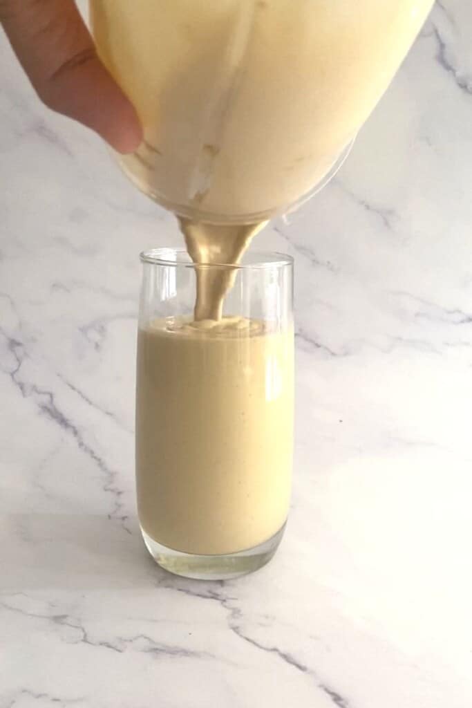 Pouring biscoff milkshake into glass.