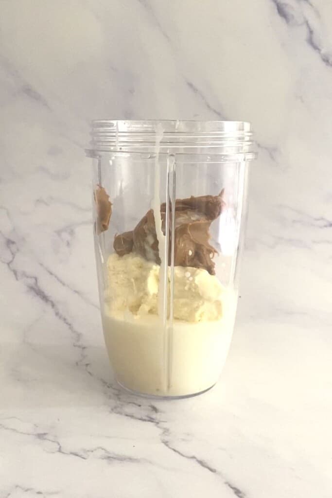 Biscoff, ice cream and milk in bullet blender.