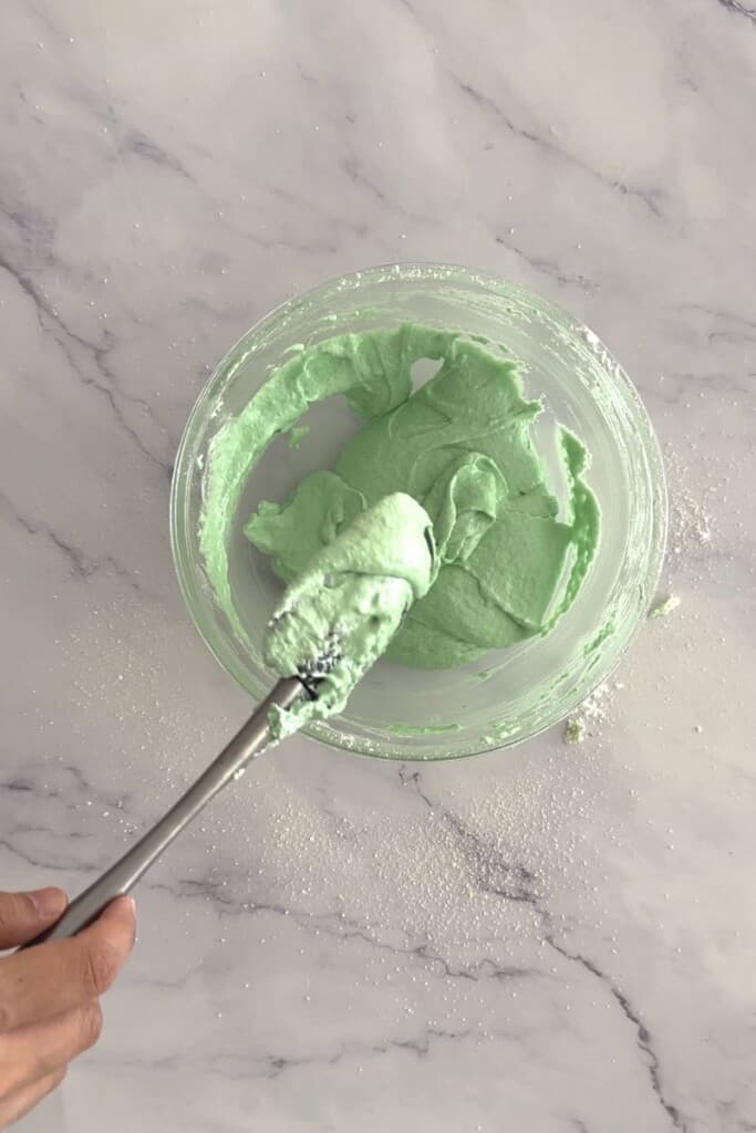 Green macaron mixture in a bowl.