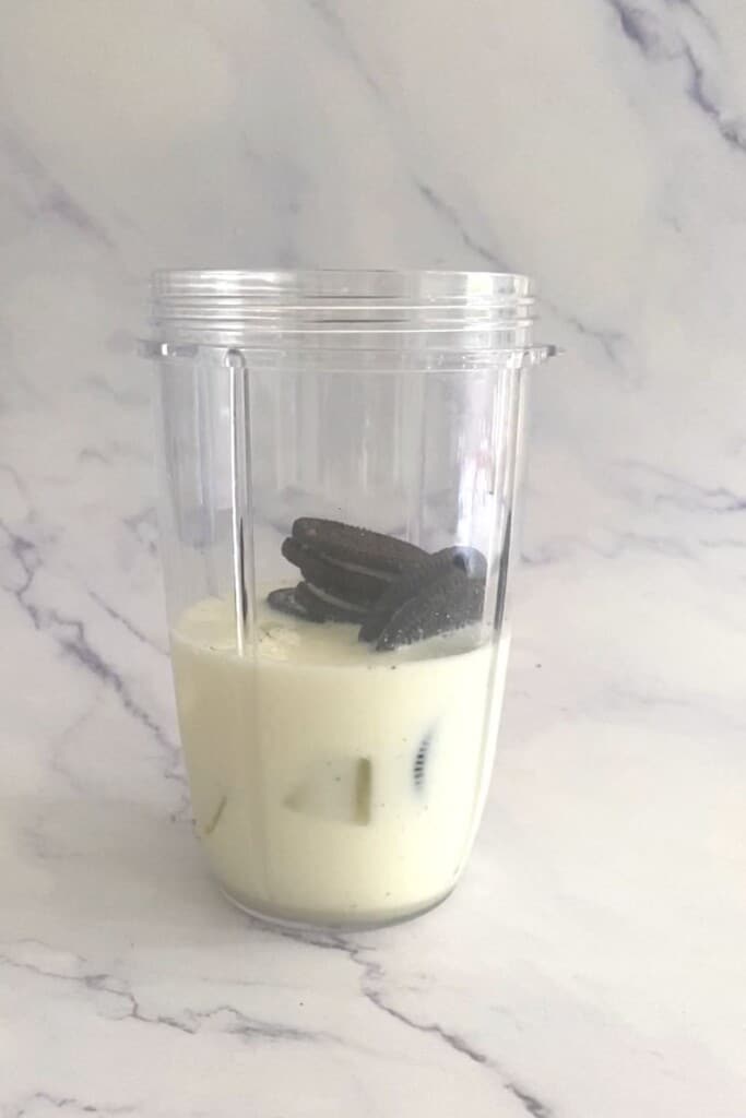 Milk, ice and oreo in blender for Oreo milkshake without ice cream.