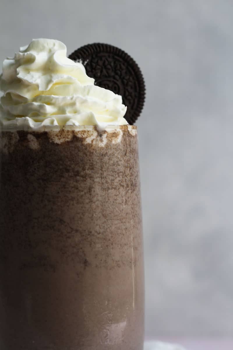 Close up of Oreo Milkshake without ice cream topped with cream and Oreos.