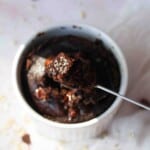Brownie baked oats in a ramekin with a spoon scooped out.