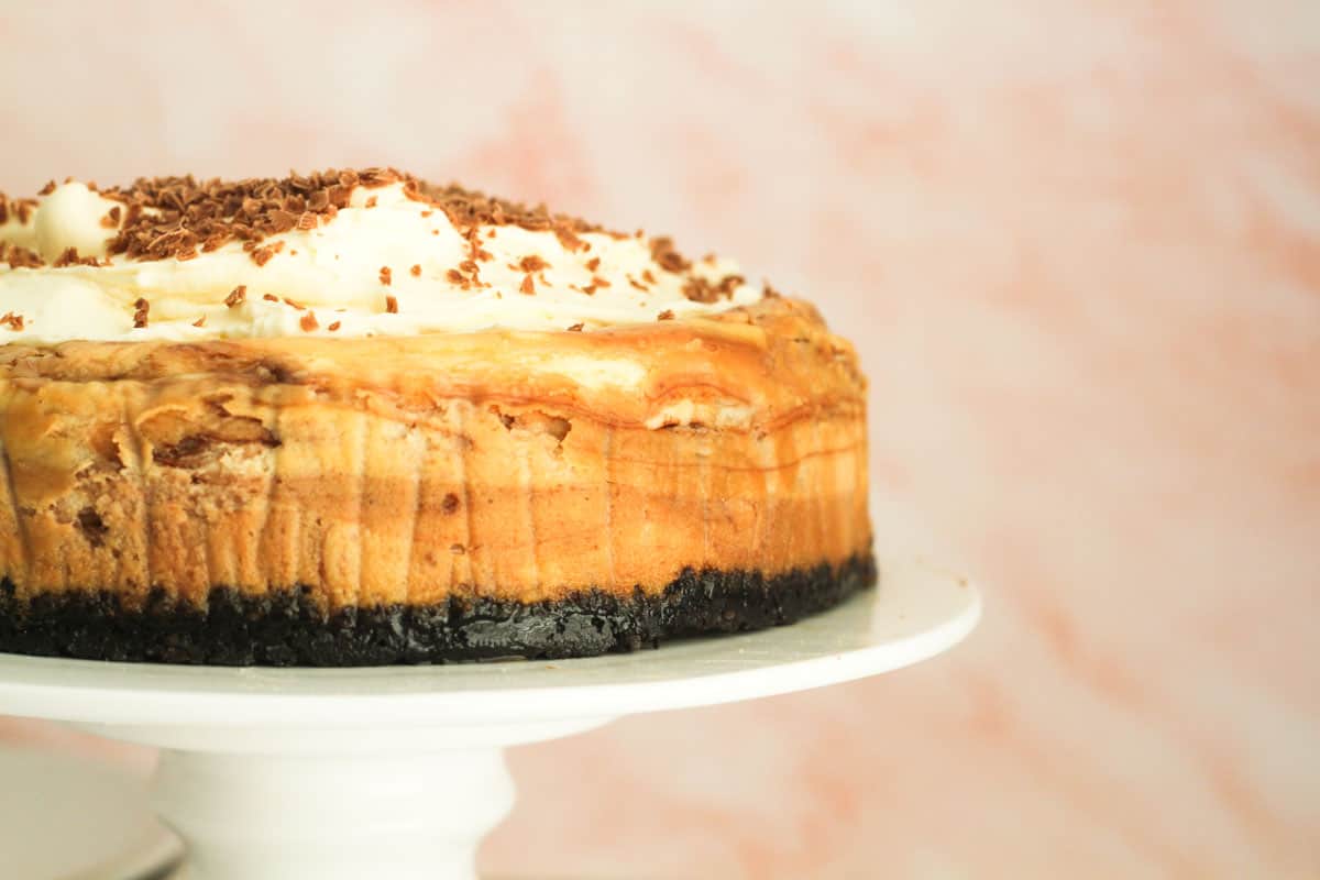 Toblerone cheesecake to the left on a cake stand.