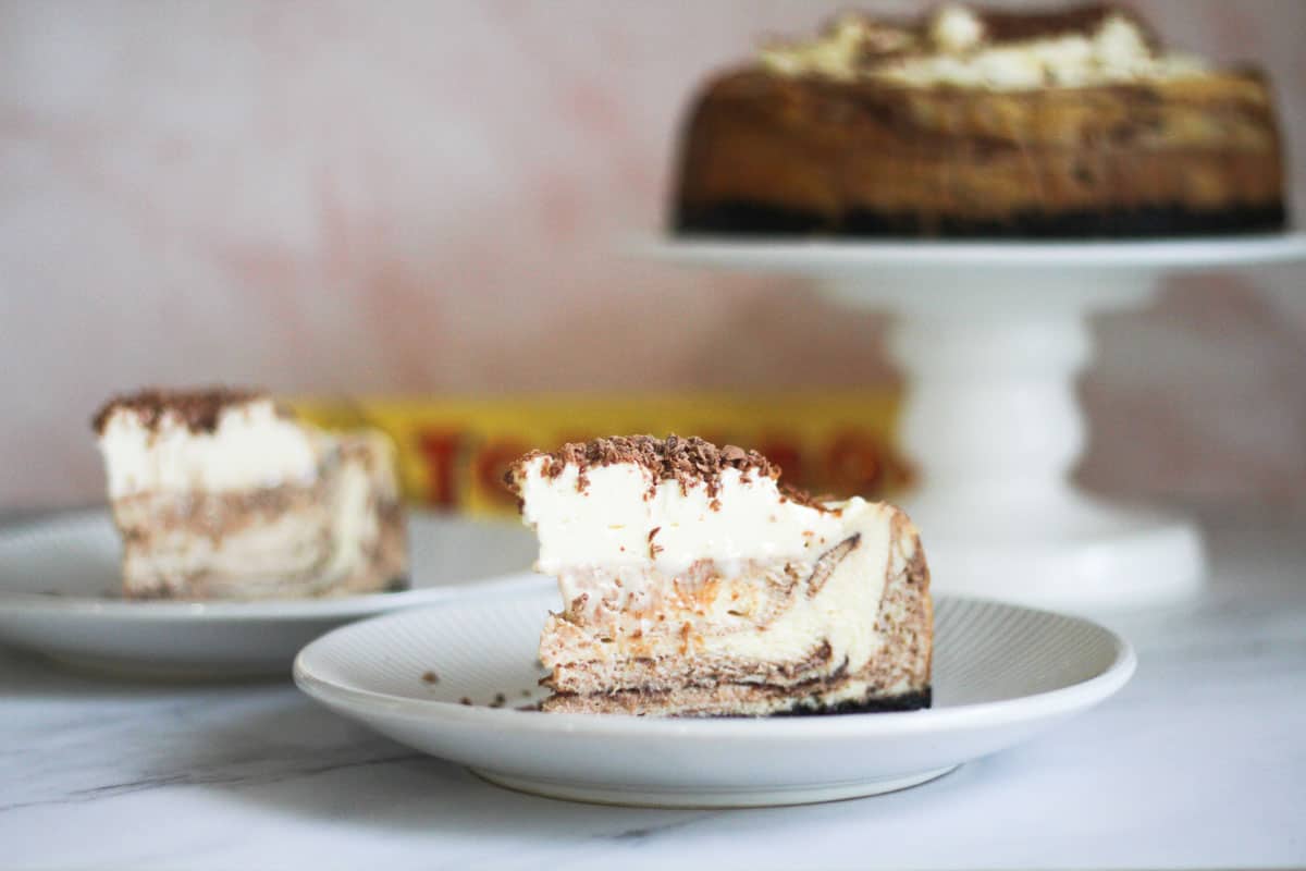 Toblerone cheesecake slices with toblerone cheesecake in the background.