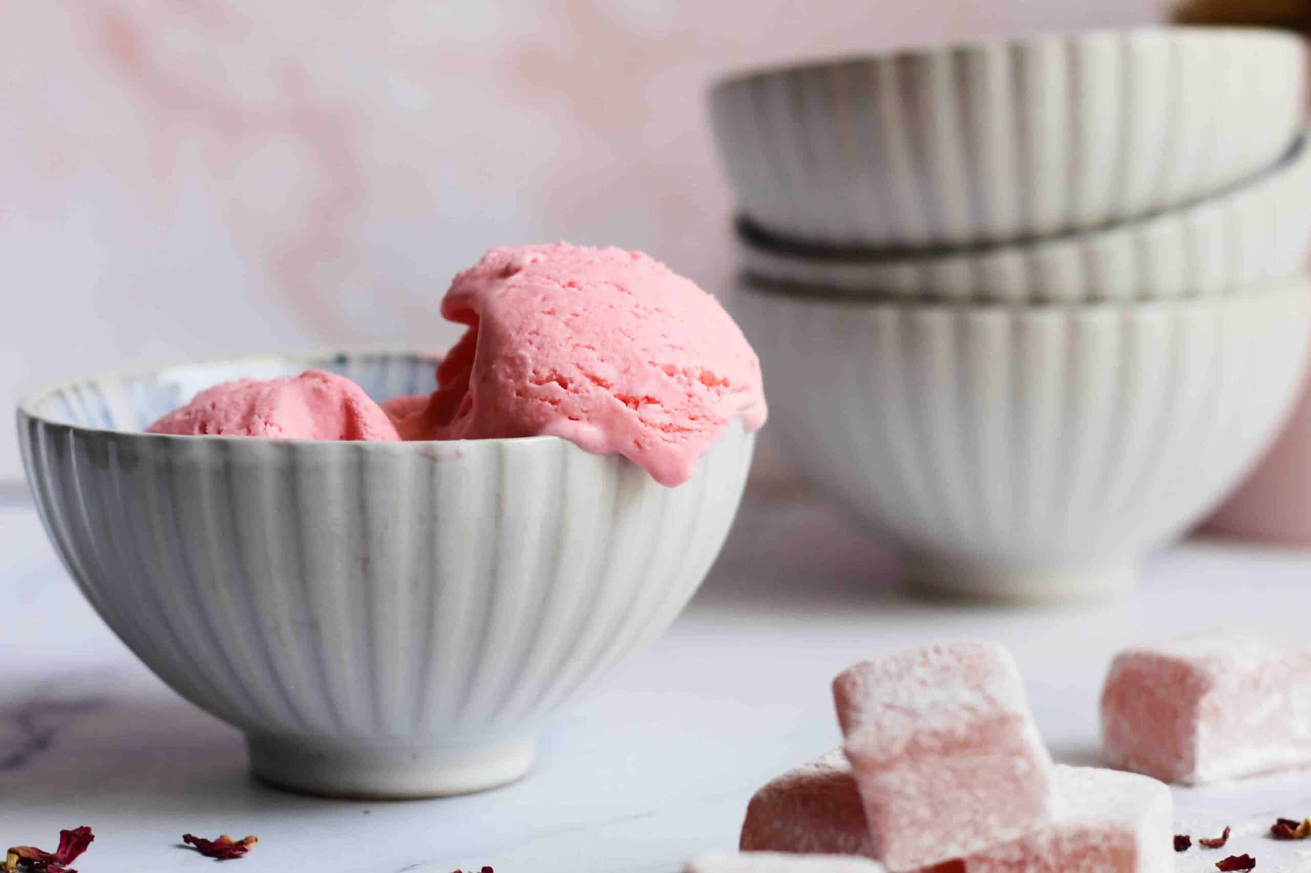 Turkish delight ice cream in a small bowl with more bowls in the background and Turkish delight in the foreground.