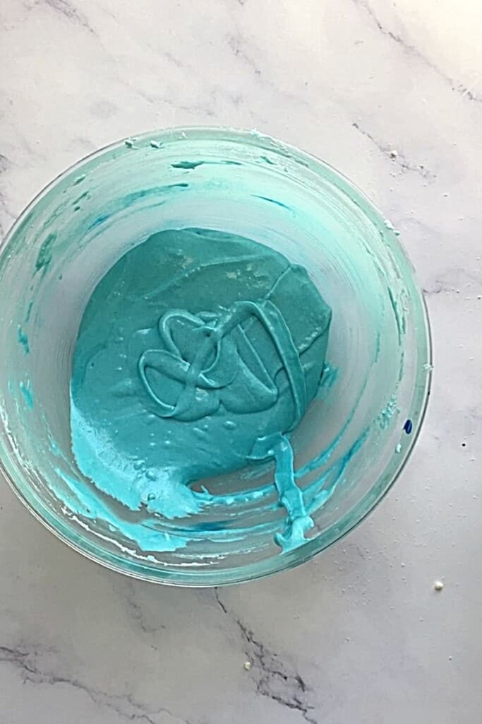 Blue macarons mixed in bowl.